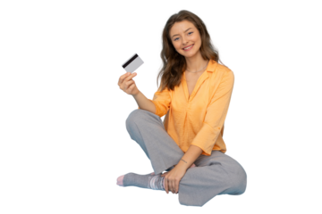 Young woman sitting with legs crossed showing credit card with transparent background