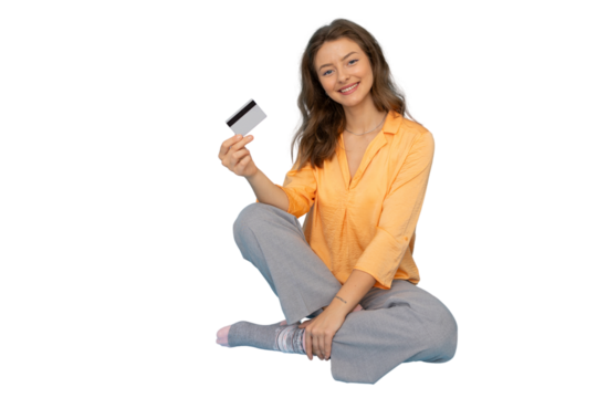 Young woman sitting with legs crossed showing credit card with transparent background