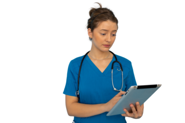 Young female doctor wearing blue scrubs and stethoscope using digital tablet, isolated on transparent background