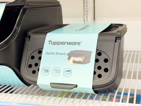 Tupperware garlic keeper on shelf with blue packaging and ventilation