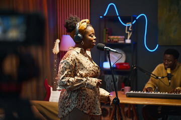 African American performer singing song during podcast in studio