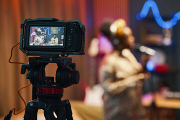 Woman performing during online podcast and singing song while operator shooting her on camera