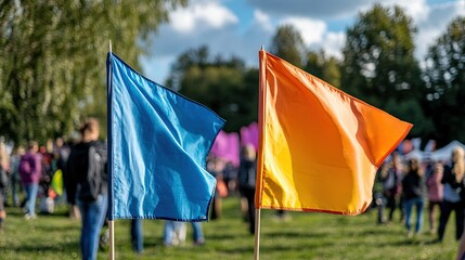 Two convex flags side by side at an outdoor event with people in the background.