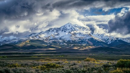 Sharp snowy mountain peak under dramatic clouds