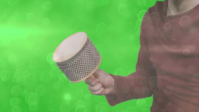 Instructor demonstrating cabasa rhythm in music education tutorial, with animated sound waves