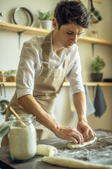 A baker in an apron kneads the dough with his hands and sprinkles it with flour to bake delicious homemade bread.