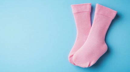 Soft pink cozy socks on a vibrant light blue background minimalist footwear fashion accessory for comfort relaxed casual wear