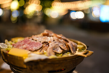 Close up view of Thai barbecue. Fresh meat on the grill and cooking pot put the ingredients into a variety. The menu is popular in Thailand.