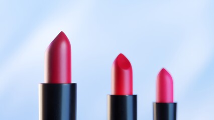 Obraz premium Red lipsticks are progressively appearing on a pastel background, changing from one to three lipsticks, with smooth transitions between scenes