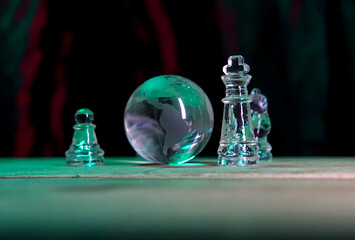 Glass chess pieces, board, and globe for global business