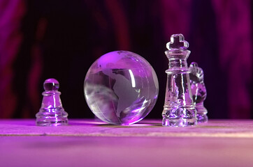 Glass chess pieces, board, and globe for global business