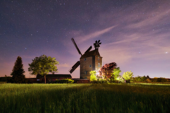 Old Paltrock windmill in Saalow at night with starry sky, Brandenburg, Germany