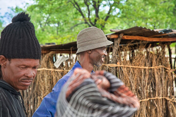 village happy smiling african man strolling in front of a shack in the yard, poverty in rural...