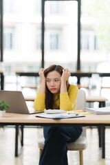 Fototapeta premium Stressed Woman at Desk with Laptop