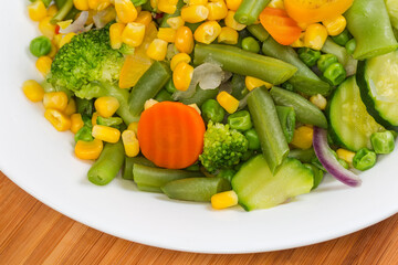 Boiled mixture of different vegetables, fragment top view close-up