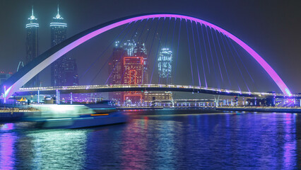 Obraz premium Pedestrian Bridge over the Dubai Water Canal night timelapse, United Arab Emirates