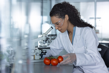 Woman Scientist Observing Tomatoes Under a Microscope