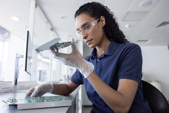 Female Technician Analyzing Circuit Board