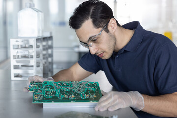 Man Inspecting Detailed Electronic Circuit