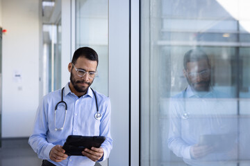 Male doctor reviewing patient data on tablet