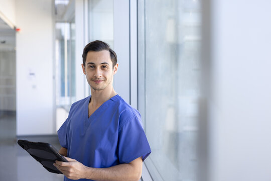 Young medical professional smiling with tablet