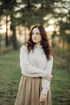 Stylish woman enjoying nature in a forest during golden hour
