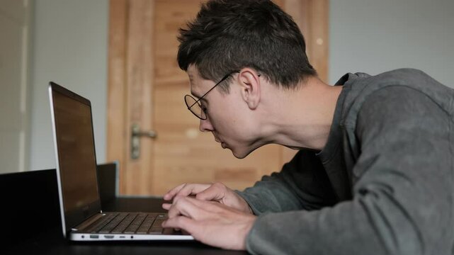 Man sitting with bad posture at desk. Hunched back from long hours at computer. Improper ergonomics during remote work.