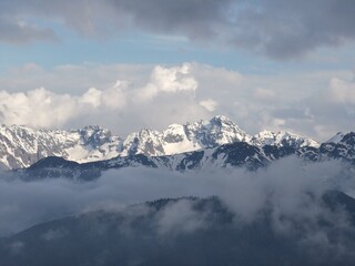 Obraz premium Stunning view of snow-covered Tatra Mountains emerging through clouds and mist, captured from Gubalowka Hill in Zakopane, Poland