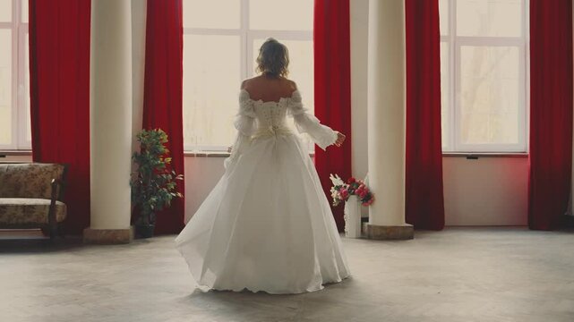 young woman queen is running in room looking out window, waiting for love beloved man. Fantasy fairy lady Happy Princess girl white silk vintage long dress old style ivory color back rear view art 4k