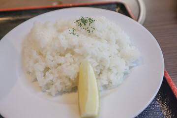 Delicious Cooked White Rice with Lemon Slice on White Plate