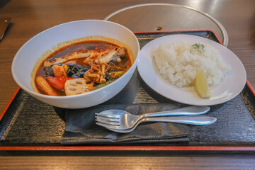Delicious Soup and Rice Served on a Black Tray with Utensils