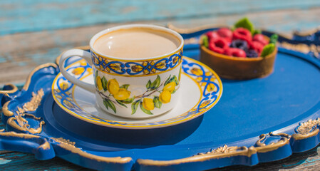 Lemon tea cup and dessert on blue tray, cozy lifestyle setting
