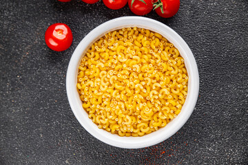 Macaroni pasta raw coquillette appetizer dish organic product fresh tasty gourmet food background on the table rustic food top view copy space