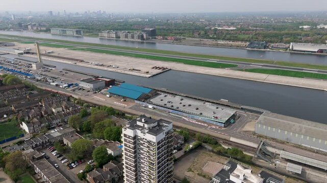 Drone Panning Left Across London City Airport, DLR Train Moving Opposite Direction