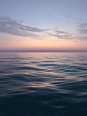 Obraz premium Calm Atlantic Ocean under a twilight sky with soft shades of pink and blue. Gentle waves reflect the colors of the sunset, creating a scene of tranquility and natural beauty.