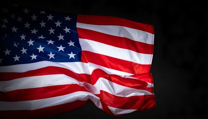 Fototapeta premium Dramatic close-up of an American flag waving against a black background.