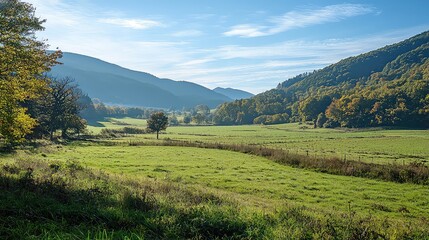 Obraz premium Lush Green Valley Encompassed by Mountains Under a Bright Blue Sky With Fluffy Clouds on a Sunny Day