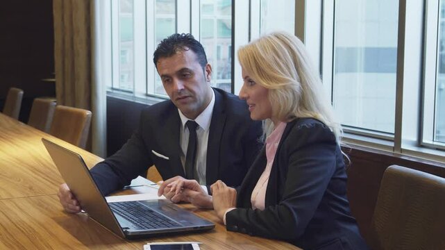 A pleased woman agrees with her partner on details of a new project