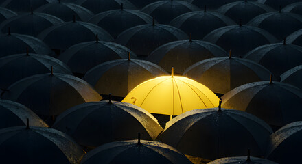 Obraz premium Close up on a Unique Illuminated Yellow Umbrella Amongst Black Umbrellas in a Dimly Lit Weather Setting
