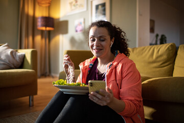 Middle aged mixed ethnicity woman tying her shoelaces and getting ready to go jogging and exercising at home