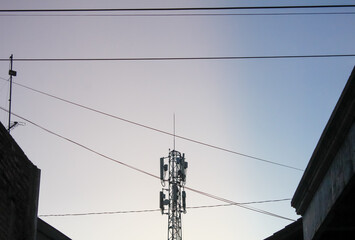Electric tower covered with many cables with blue sky background