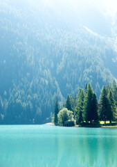 View of turquoise alpine lake lago di Anterselva in Italian Dolomites in south Tyrol with a forest mountain in the background
