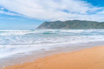 The coast of the island of Sardinia in Italy. Beautiful beaches in Europe. A postcard from a vacation. Waves on the beach on the coast. Waves crashing on the coast.