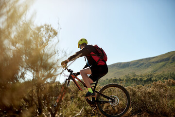 Naklejka premium Nature, sports and man cycling on dirt road for gravel race, challenge or competition training. Fitness, mountain bike and athlete cyclist driving on trail outdoor for exercise or workout with speed.