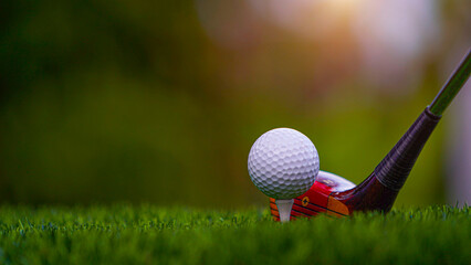 Golf clubs and balls on a green lawn in a beautiful golf course with morning sunshine.