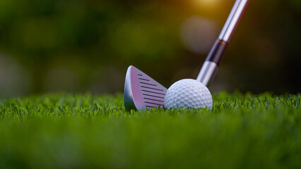 Golf clubs and balls on a green lawn in a beautiful golf course with morning sunshine.