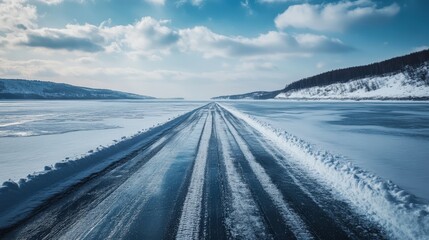 Obraz premium A road tour along a frozen lake, tire tracks visible in the snow as the journey continues.