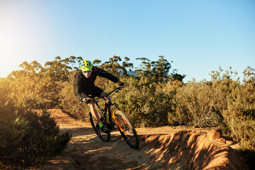 Naklejka premium Mountain bike, training and man with fitness, dirt road and environment with competition. Hobby, adrenaline or cyclist with practice, travel or challenge with adventure, journey or nature with energy