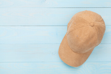 Beige velvet cap on wooden background, top view
