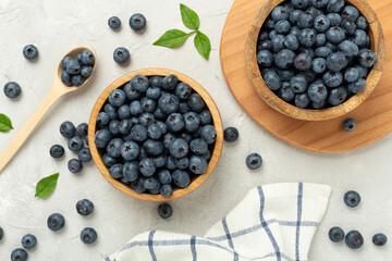 Bowl with fresh bright blueberries on concrete background,top view